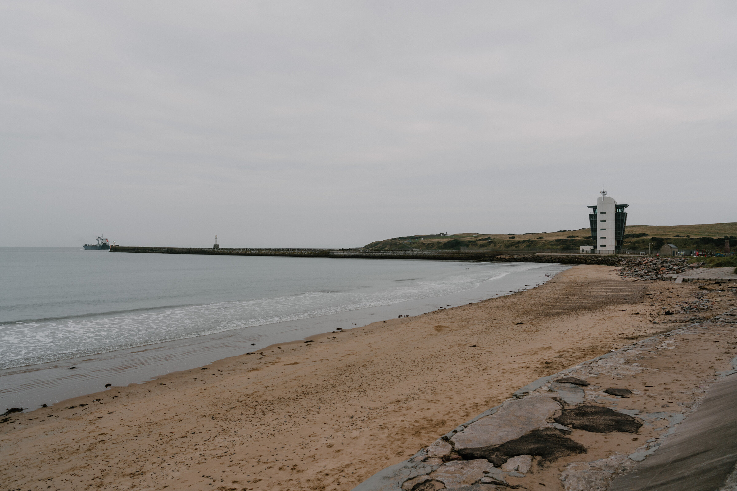 Aberdeen's beach curving round to the harbour breakwater and its lighthouse.
