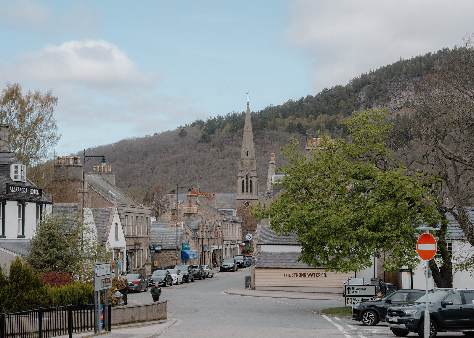 Ballater's high street runs past the Alexandra Hotel towards a church spire beneath wooded hills