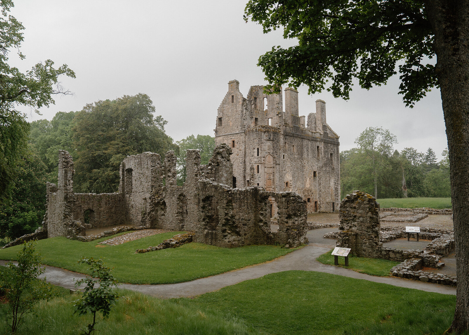 The ruined tower and hall of Huntly Castle rising above mown grass