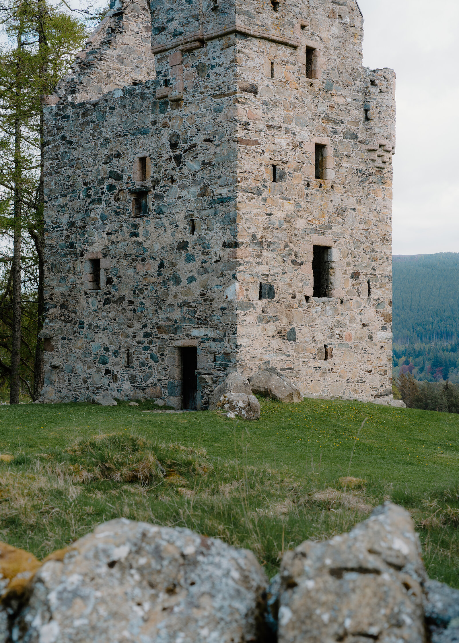 The stepped-gable tower of Knock Castle standing in a grassy clearing among trees