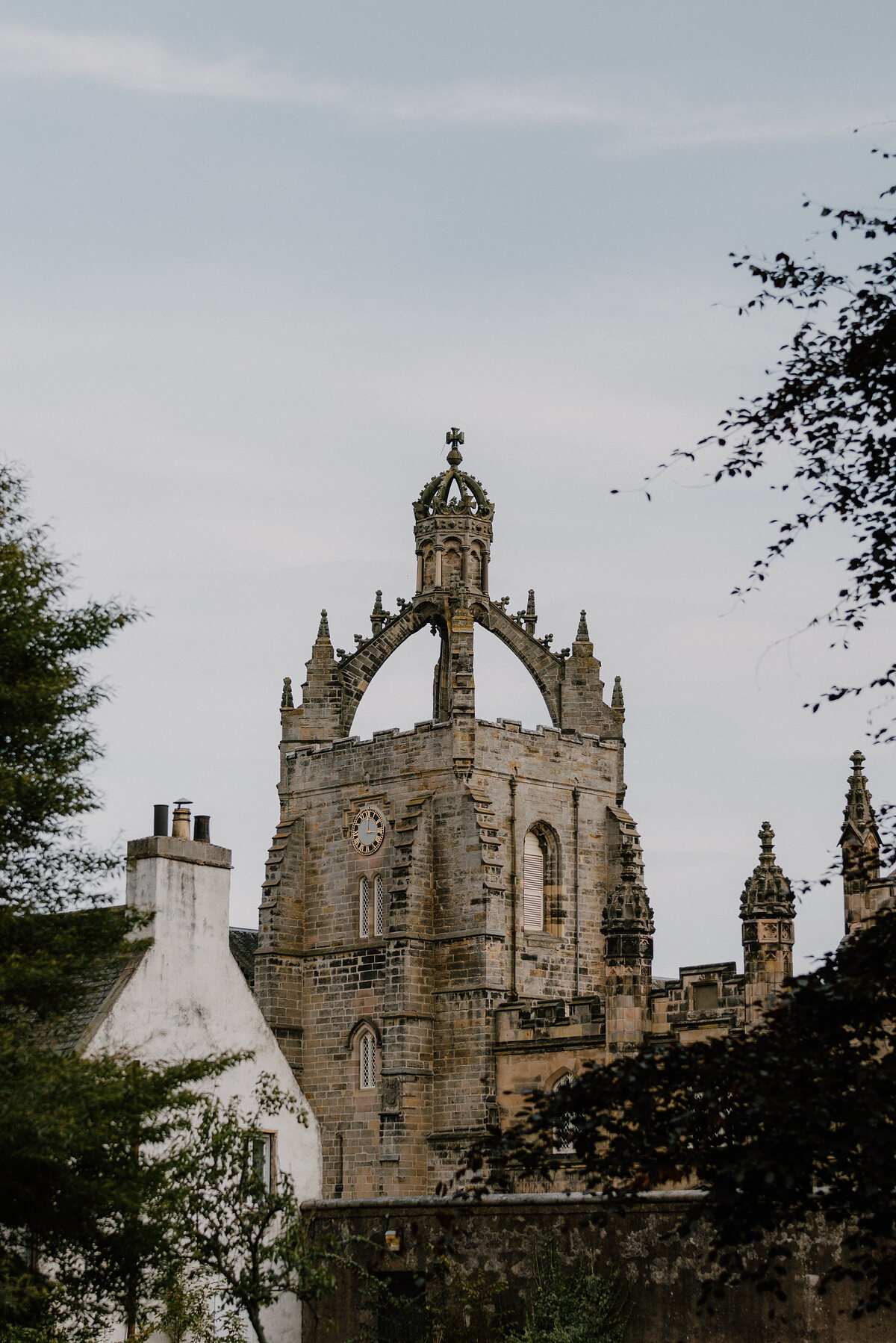 The crown-topped tower of a college chapel in Aberdeenshire, its clock face set beneath carved pinnacles.
