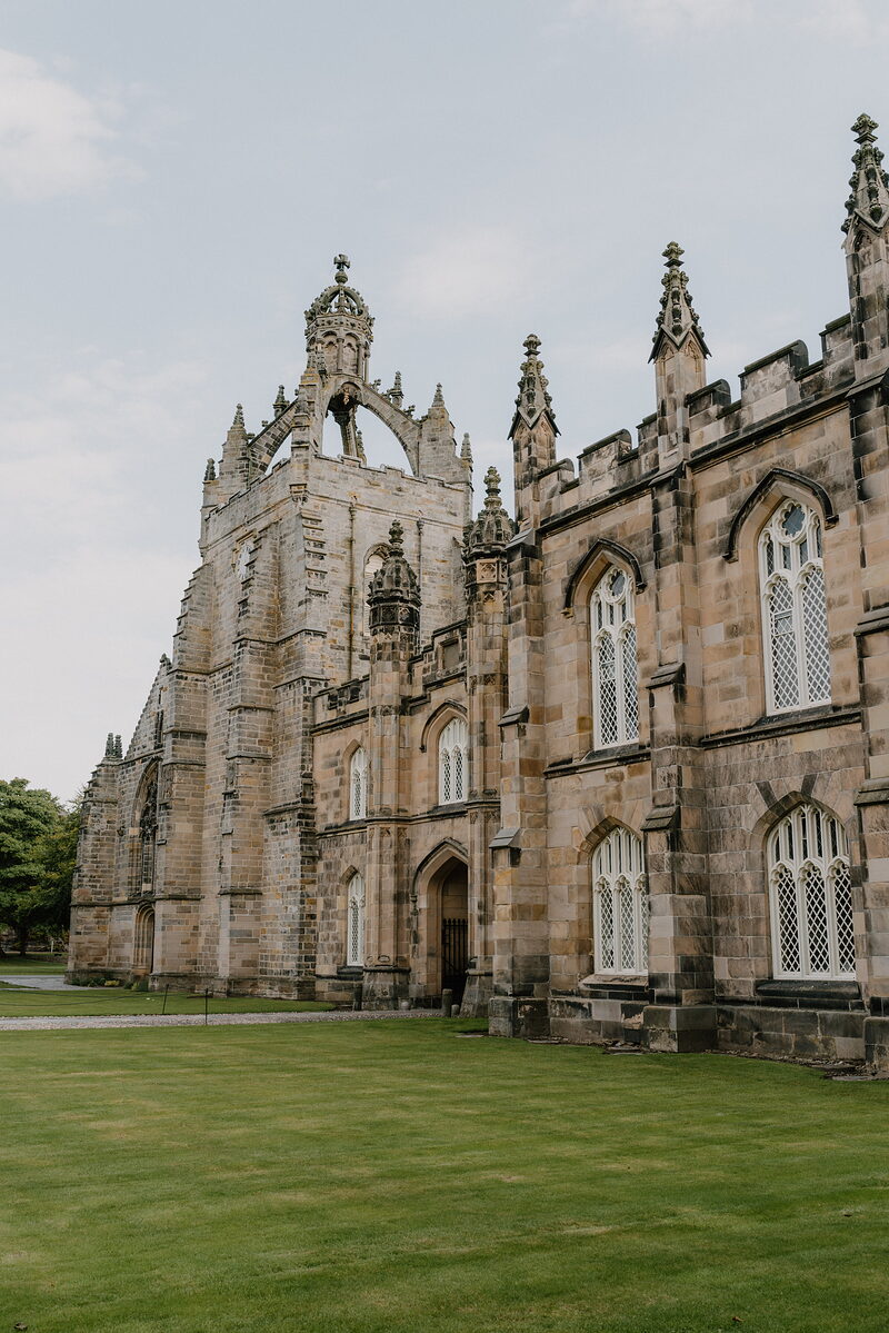 The crown-towered chapel of a college in Aberdeenshire, its Gothic windows and lawn stretching before it.