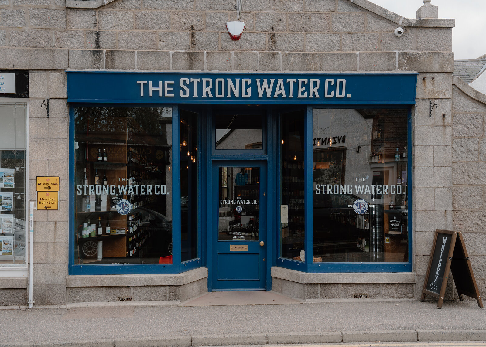 The Strong Water Co shopfront with blue-framed windows and a sandwich board on the pavement