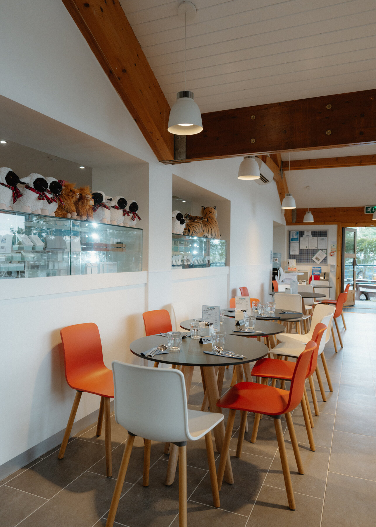 Orange chairs surround round tables in the power station's timber-beamed cafe.