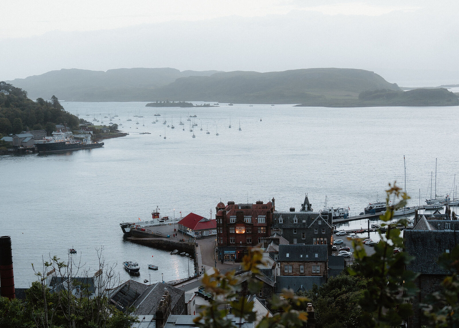 The bay and its moored yachts with Kerrera beyond, the red sandstone of the Columba Hotel and the north pier below.