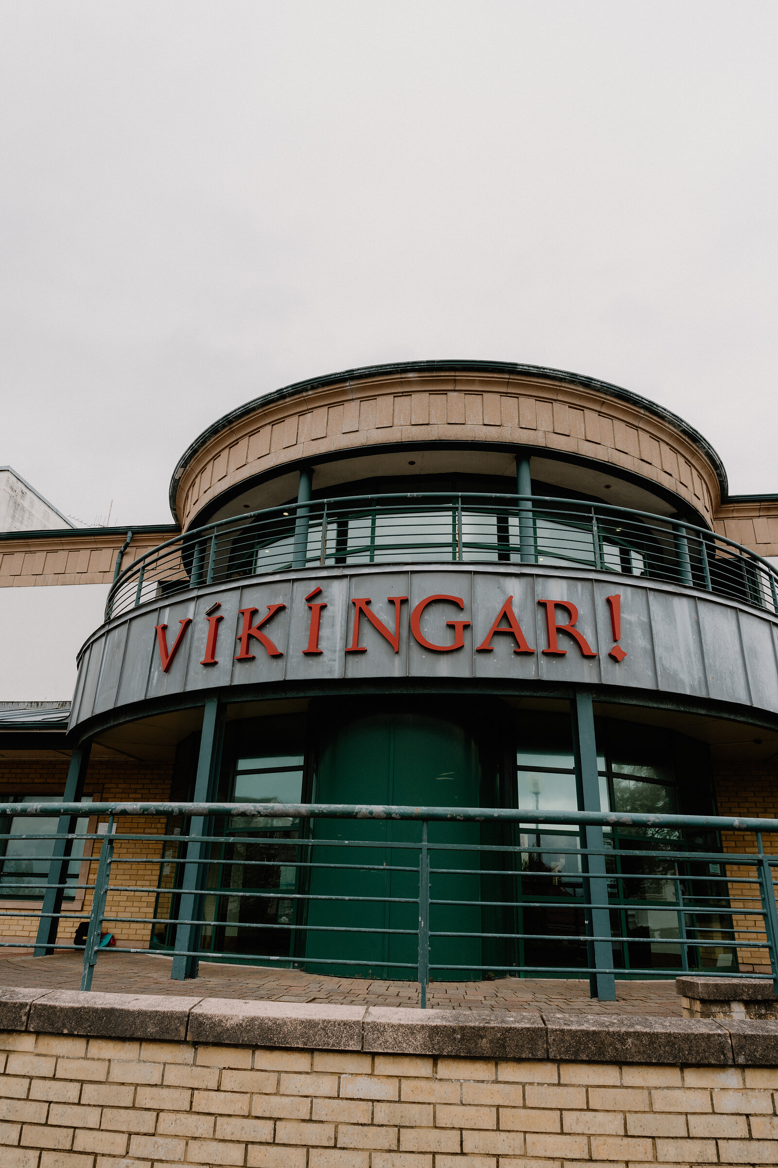 A curved building with a glazed upper storey carries the sign "Vikingar!" in red lettering above its entrance.