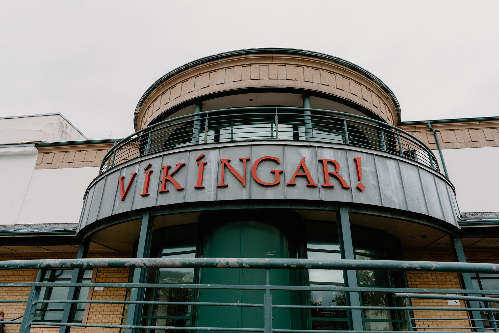 A curved building carries the sign "Vikingar!" in red lettering above a glazed upper storey and railed balcony.