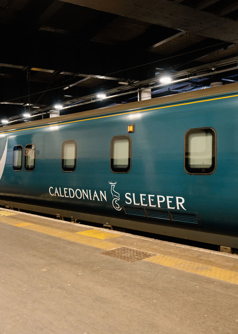 The sleeper drawn up at the platform, lit from the canopy above.