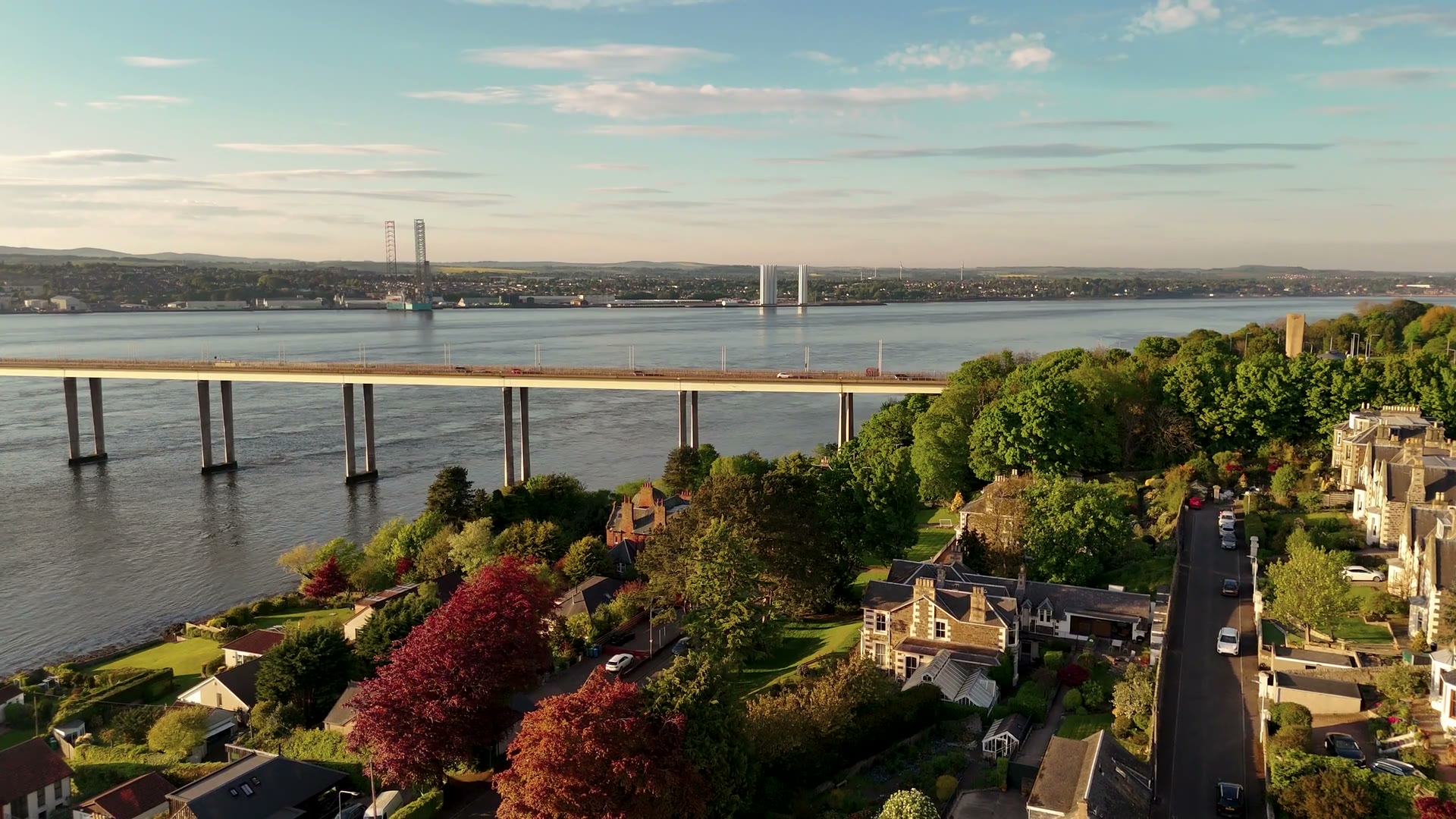 Along the Tay Road Bridge in the warm evening light, the rigs laid up in the firth beyond.