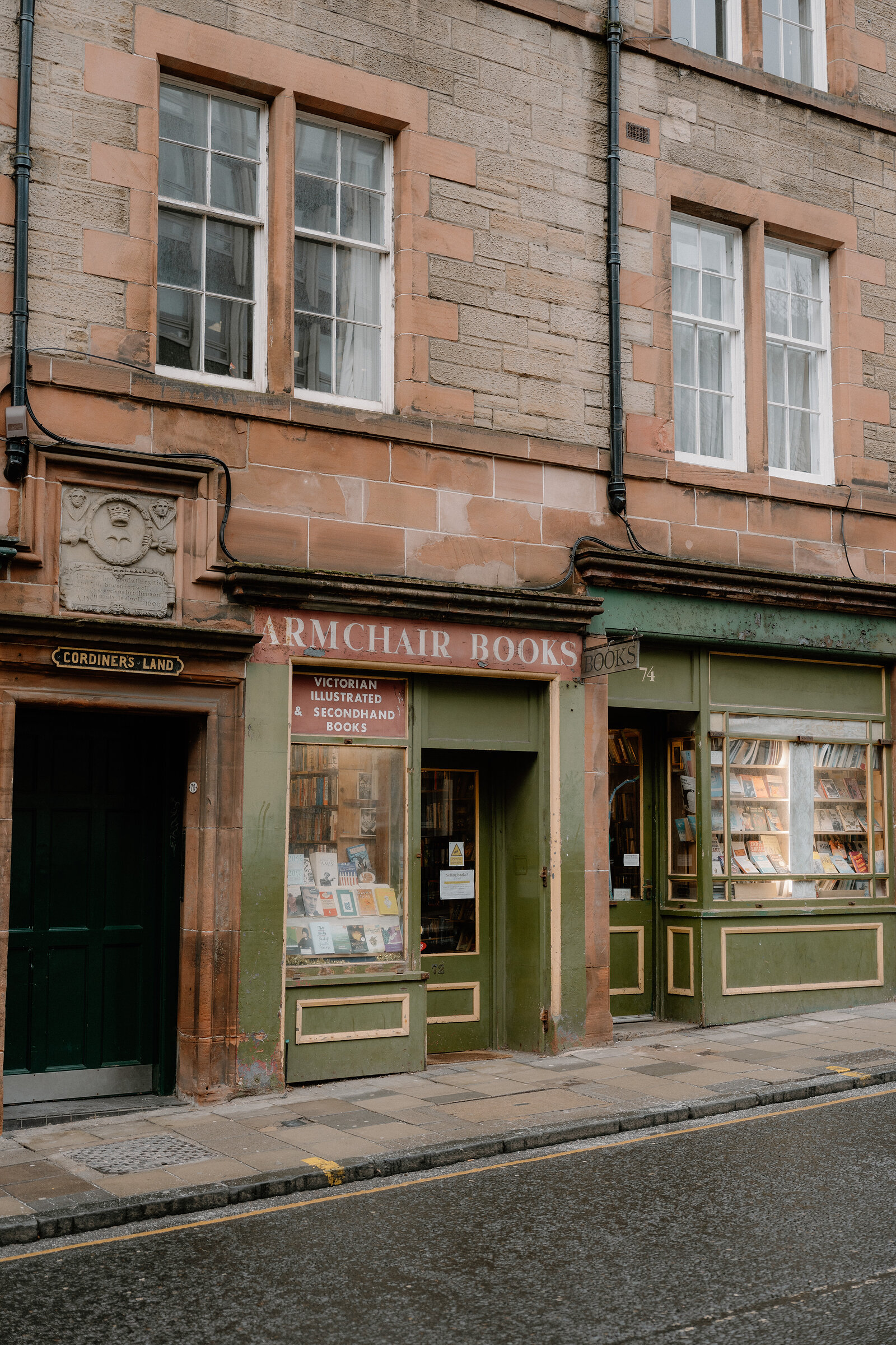 Secondhand books fill the window displays of 'Armchair Books' on a quiet street corner.