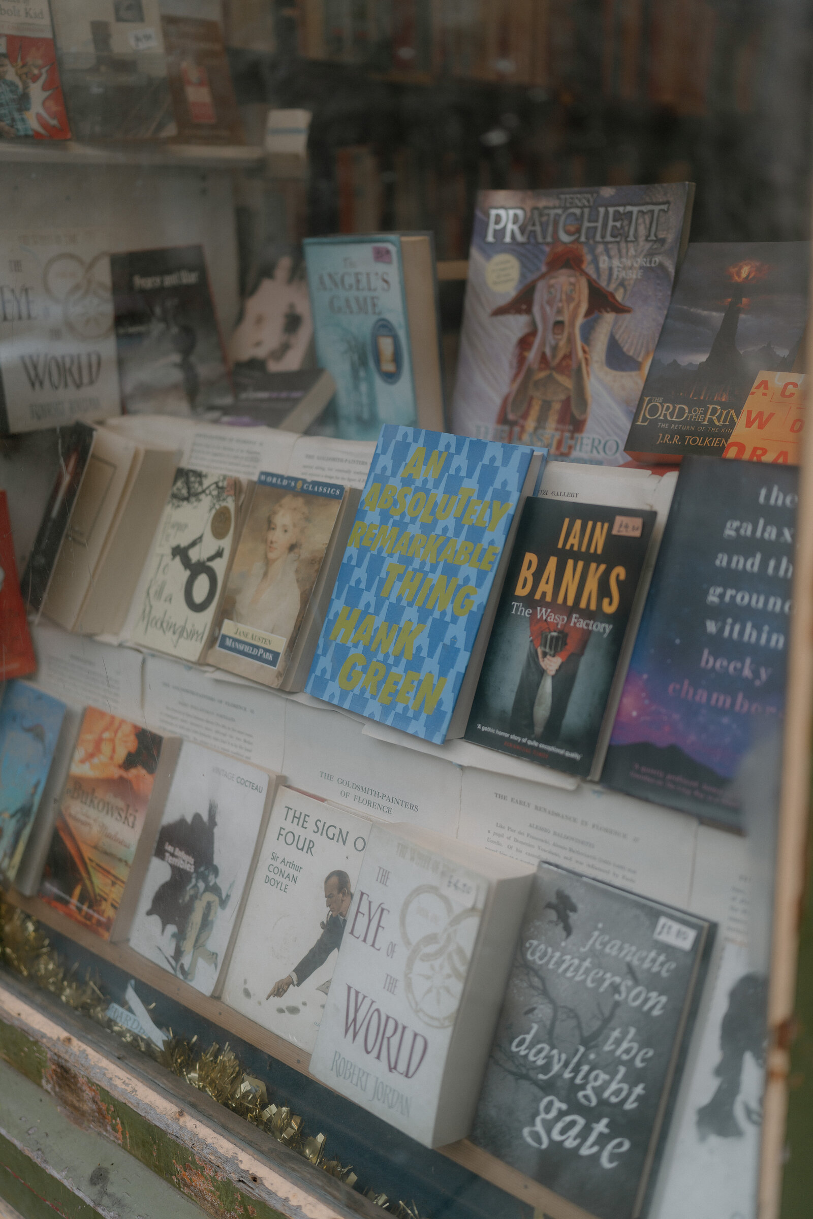 Paperback novels fill a bookshop's window display.
