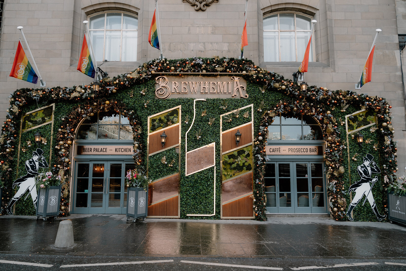 Brewhemia's own sign above its hedge-covered entrance, decorated with rainbow flags.