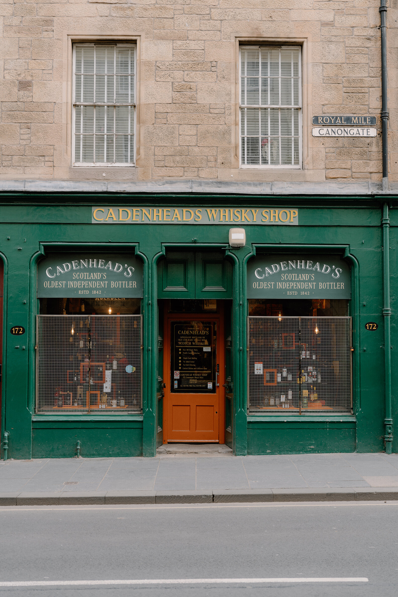 Cadenhead's Whisky Shop's own green storefront on the Royal Mile, a "172" address plate beside its door.