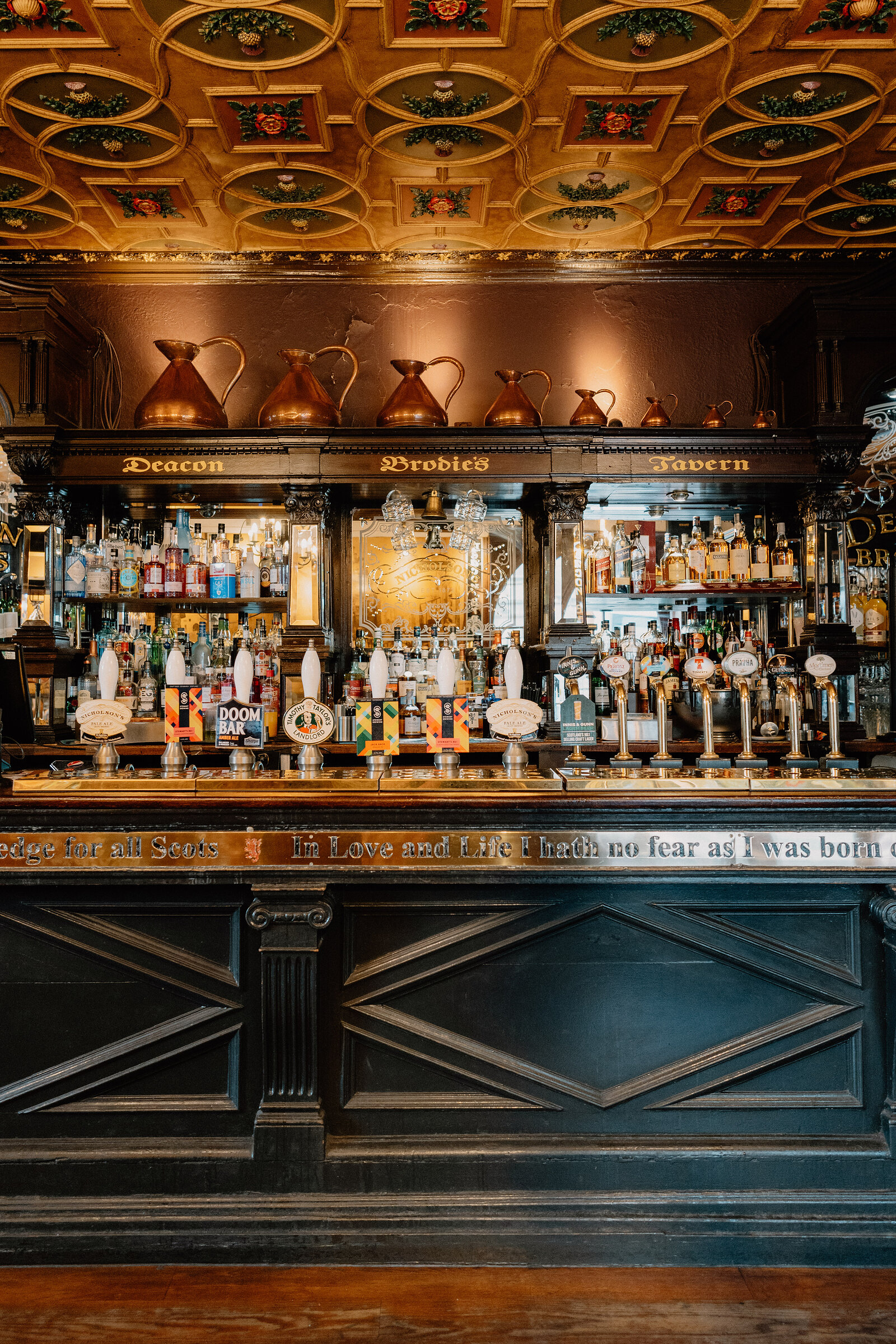 Copper jugs line the gilded bar shelves inside Deacon Brodie's Tavern.
