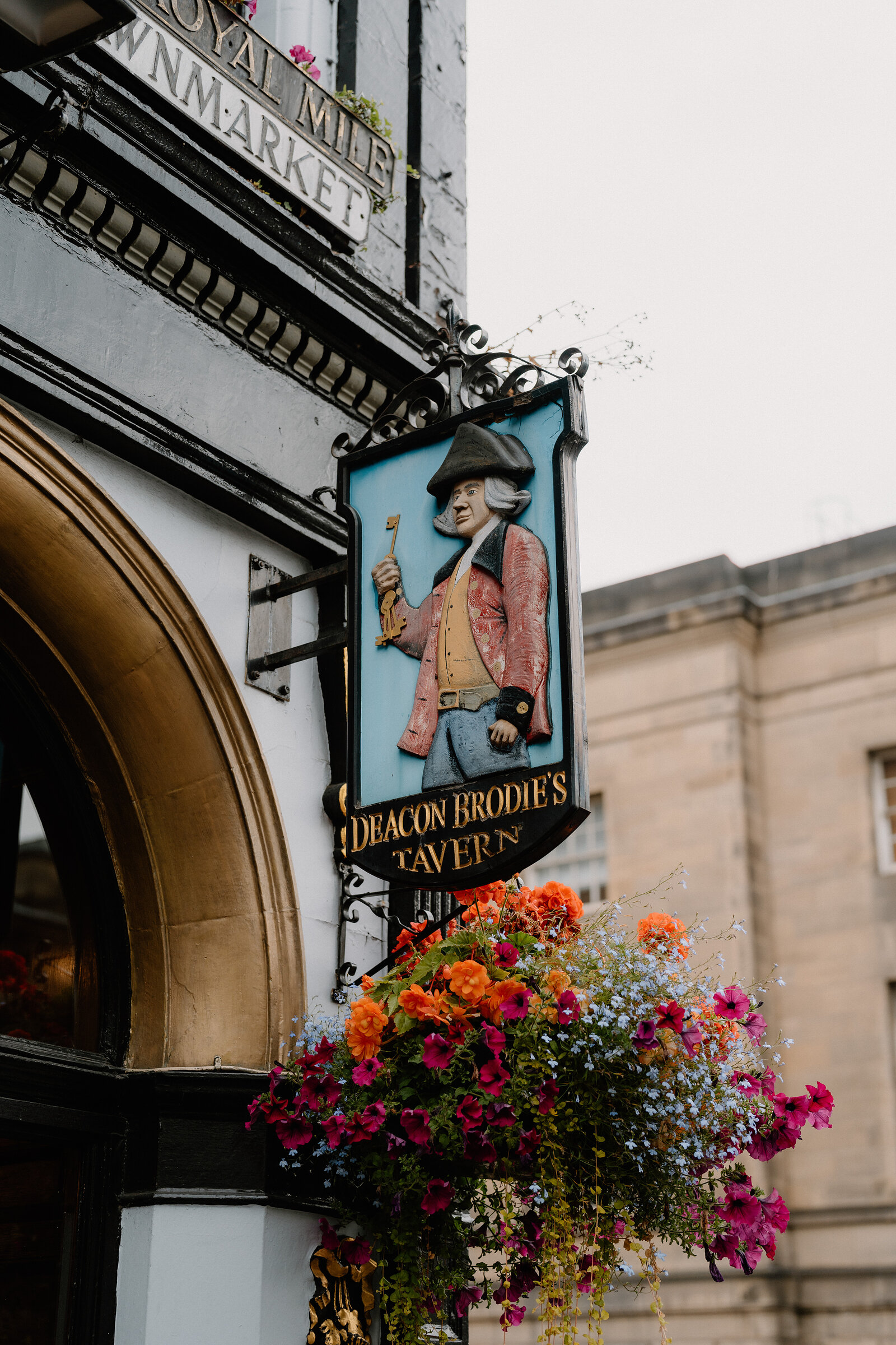 Deacon Brodie's Tavern's painted hanging sign shows him in period dress above flower baskets.