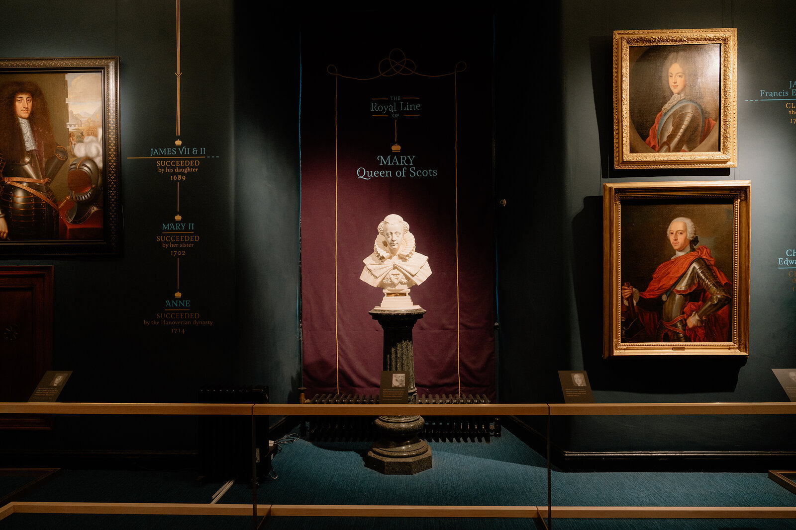 A marble bust labelled 'Mary, Queen of Scots' stands on a plinth beneath a banner reading 'The Royal Line'.