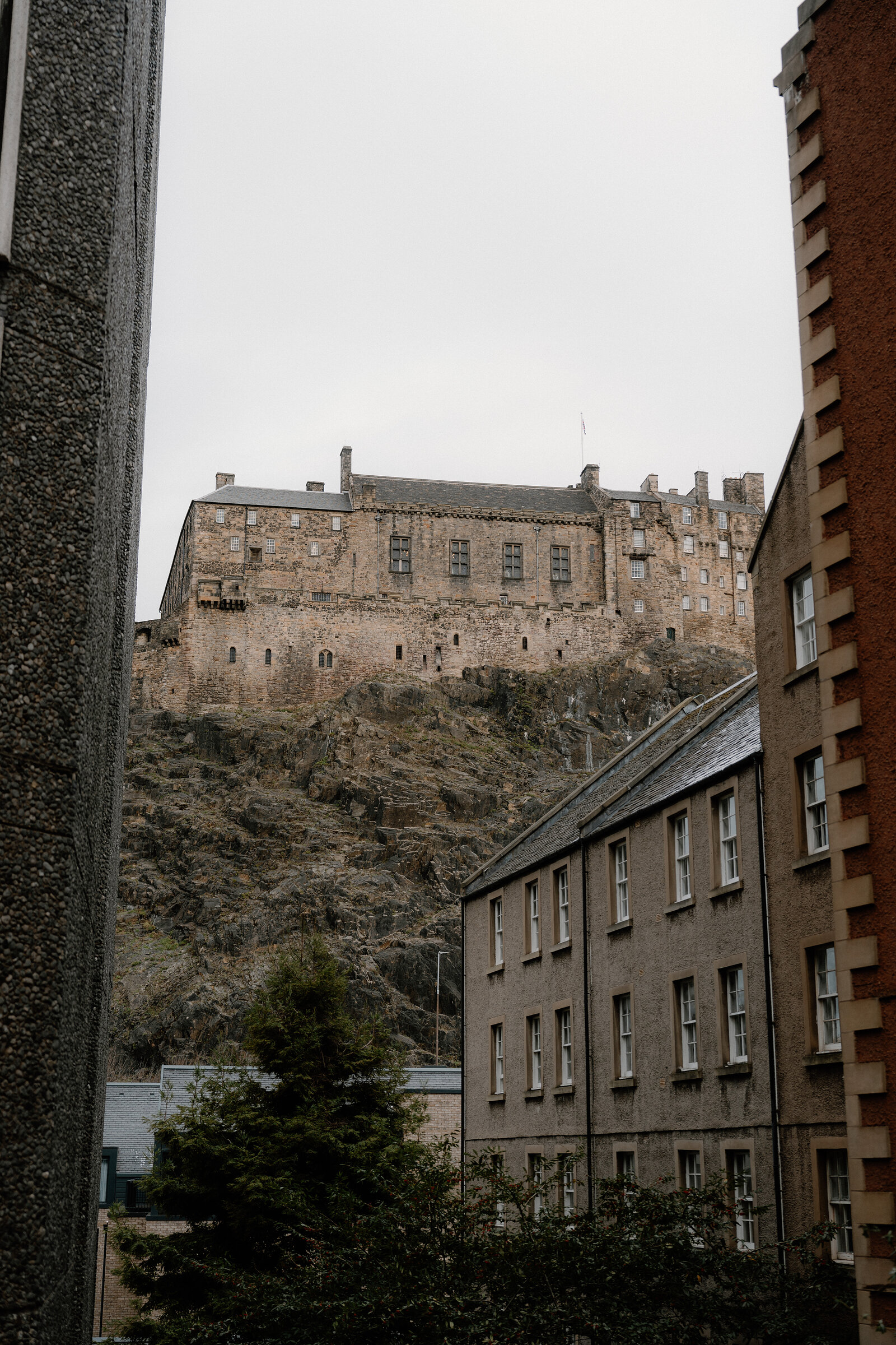 Edinburgh Castle stands on its rocky crag above rows of stone tenement buildings.