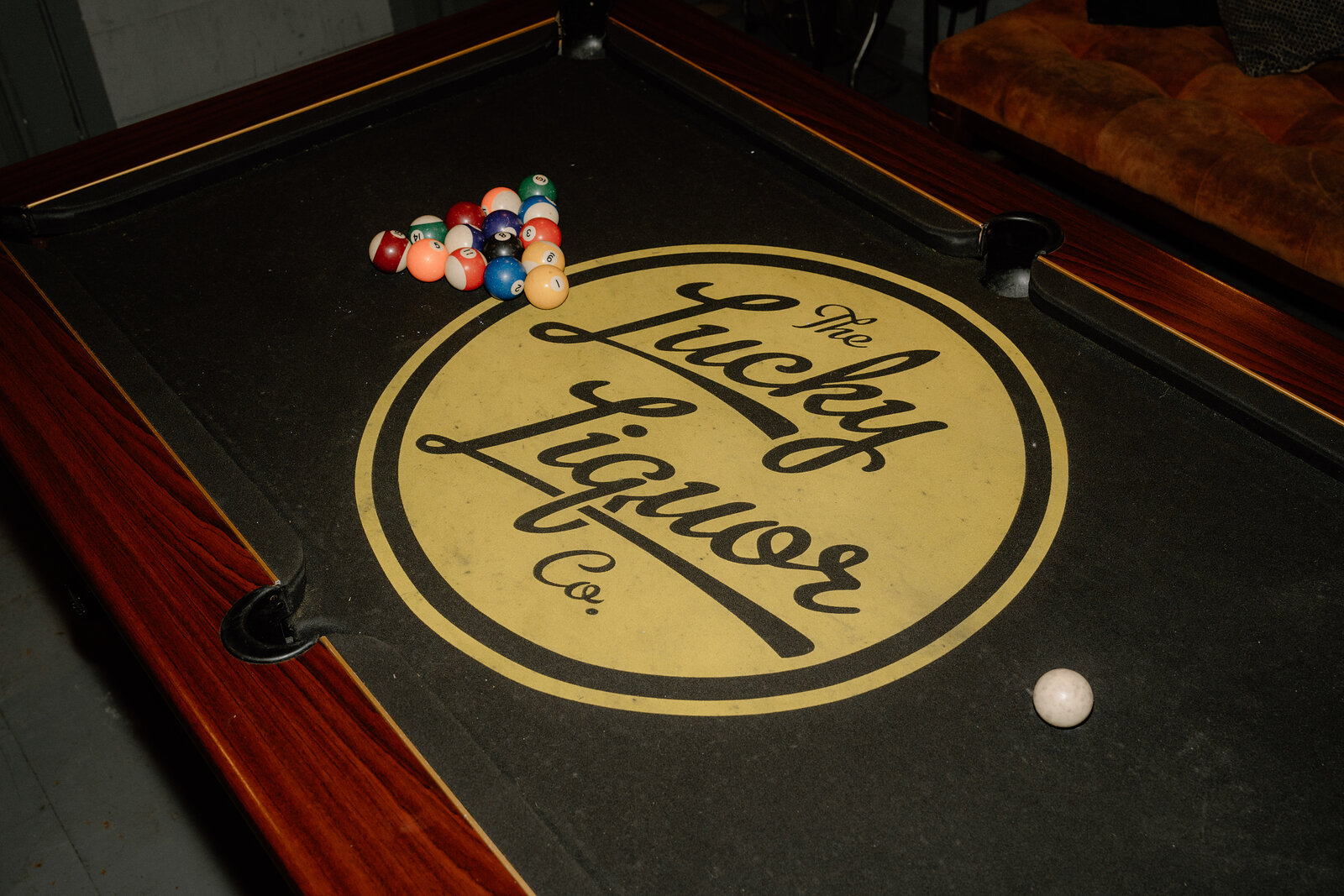 Racked balls sit on The Lucky Liquor Co's branded pool table felt in an Edinburgh basement bar.