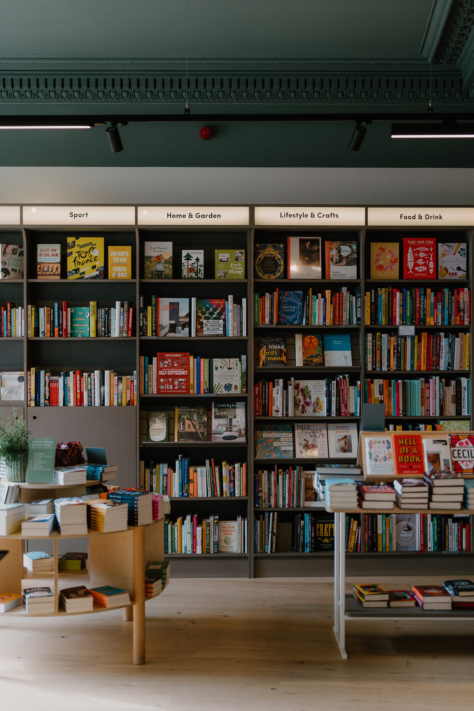 Labelled bookshelves and display tables fill a room in The Portobello Bookshop.