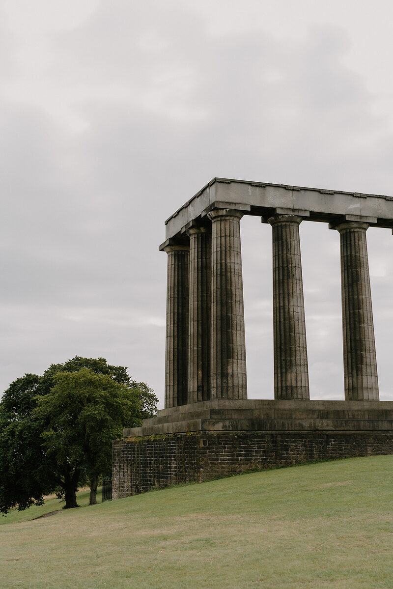 The National Monument's unfinished columns stand on Calton Hill beside a lone tree.