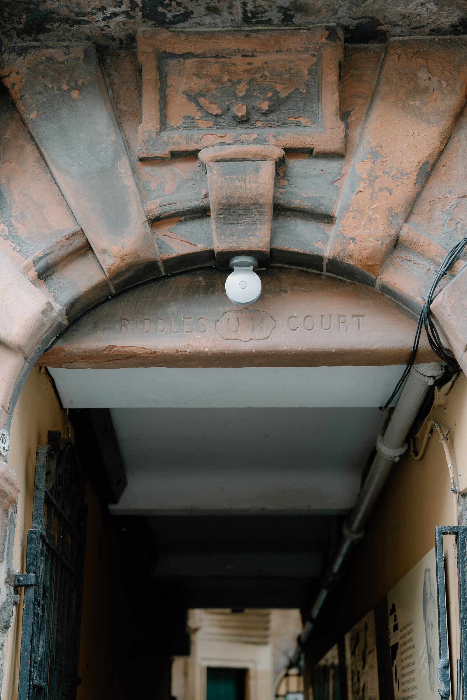 An arched passage inscribed Riddle's Court leads into a shadowed close