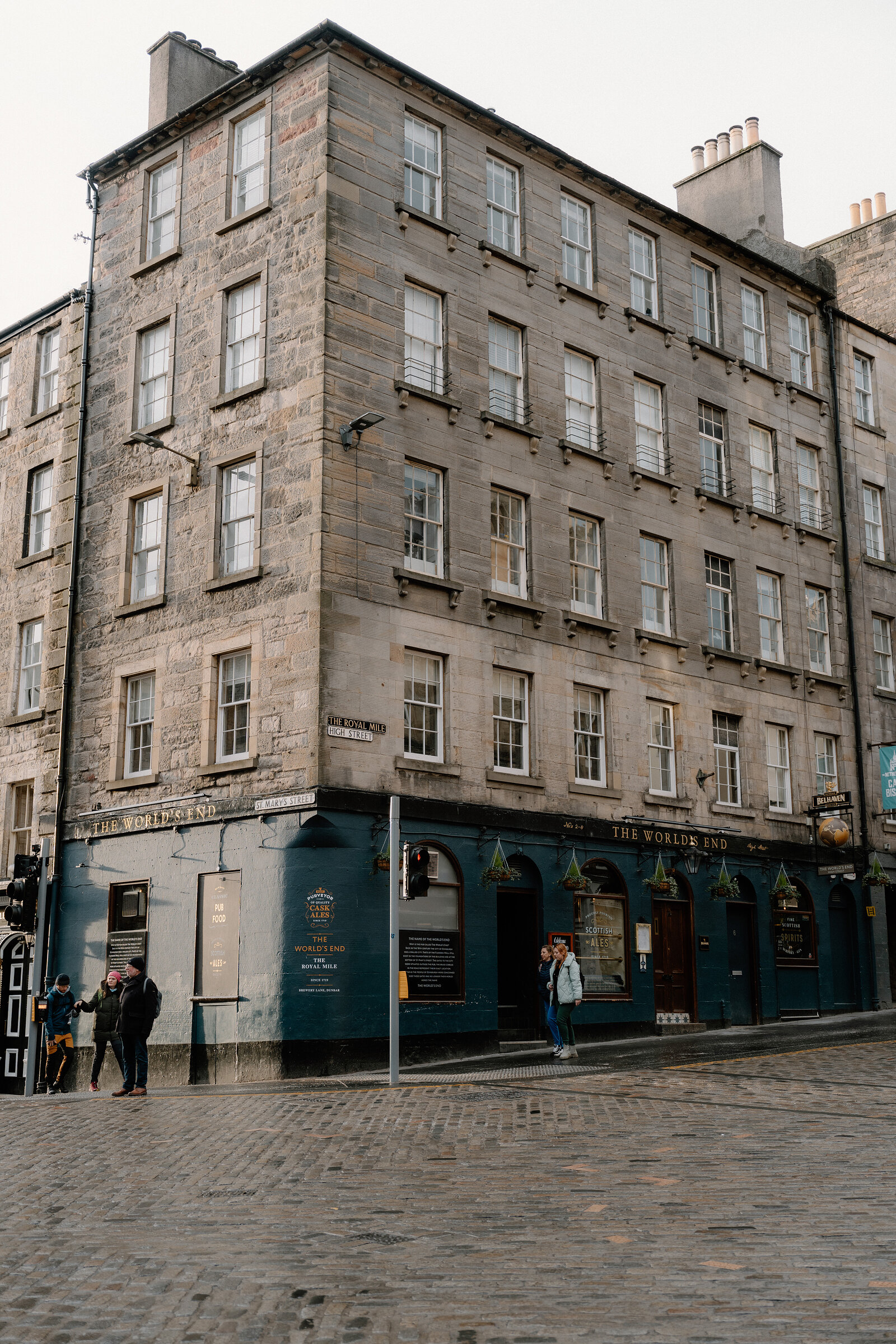 The corner building of The World's End pub on the Royal Mile, pedestrians passing below