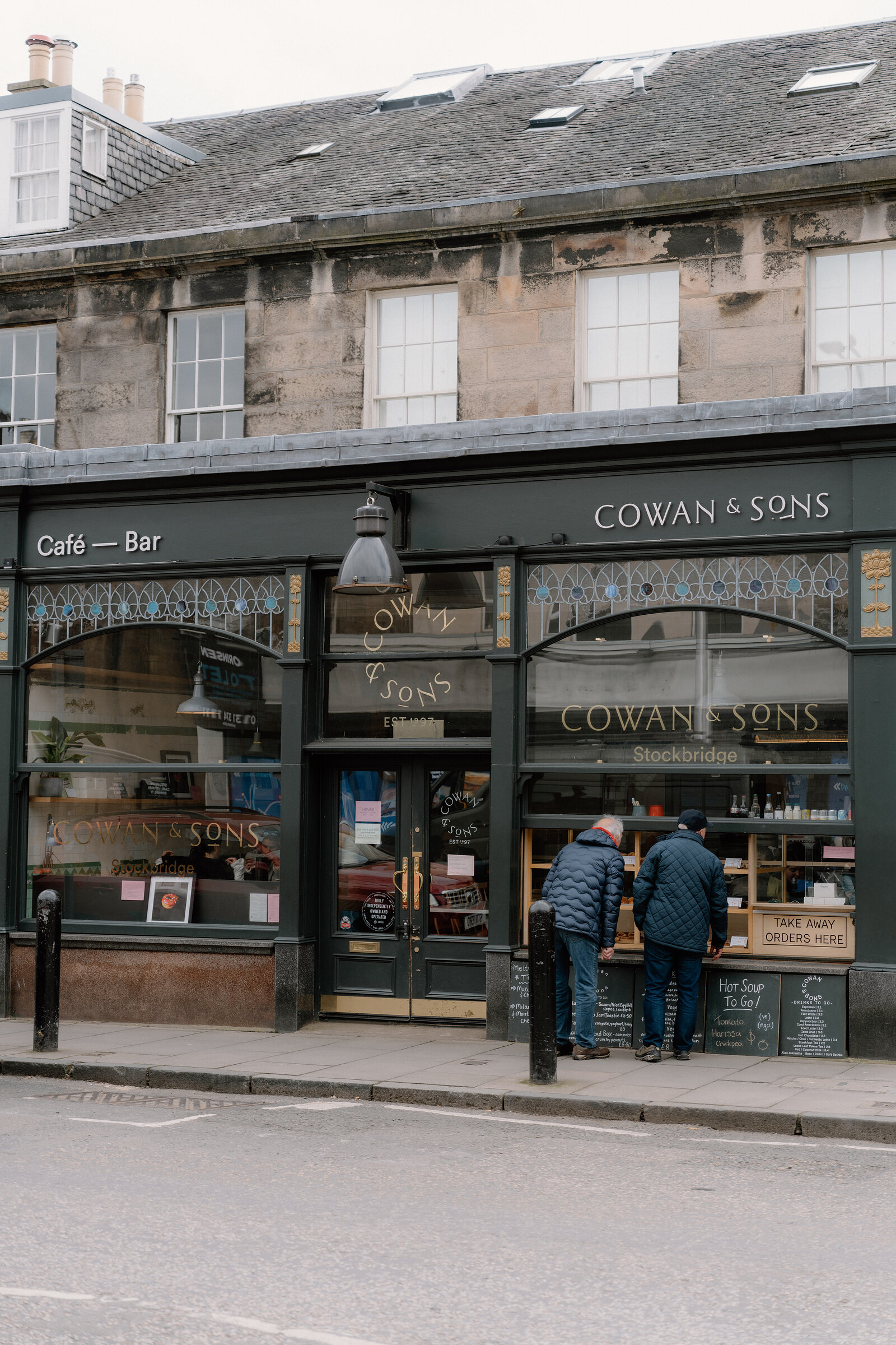 The green-fronted Cowan & Sons cafe-bar in Stockbridge, customers waiting at the takeaway hatch.