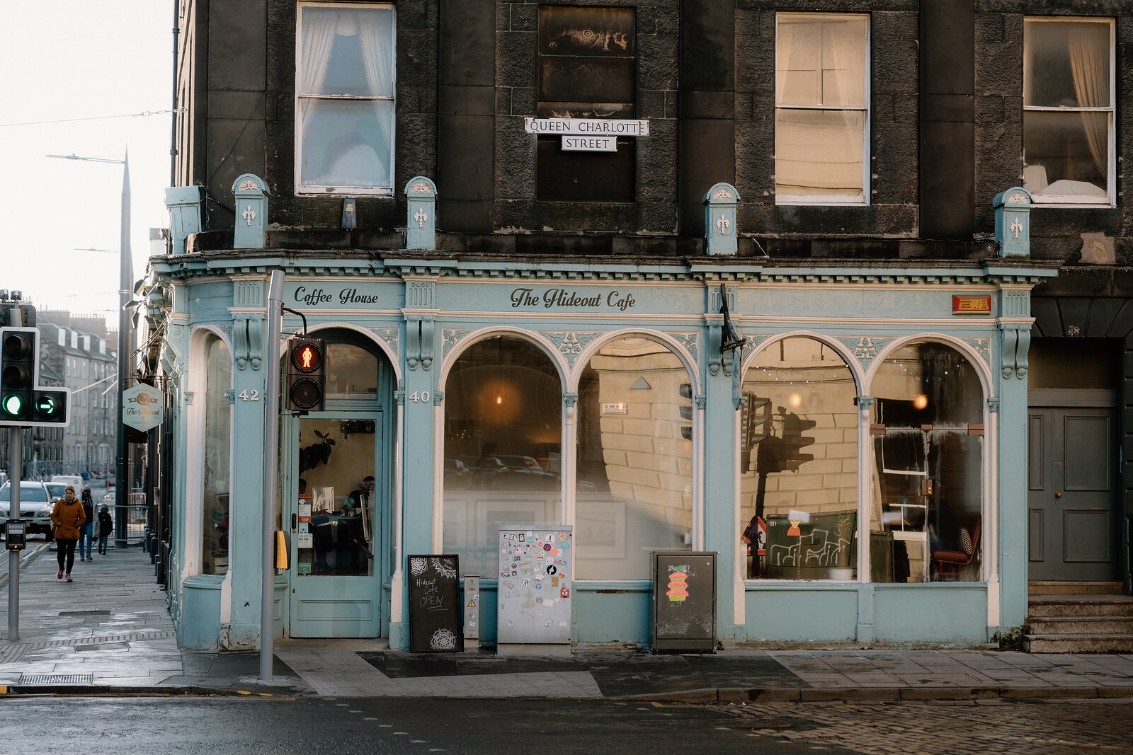 The pale blue corner shopfront of the Hideout Cafe, its arched windows and Coffee House lettering on Queen Charlotte Street.