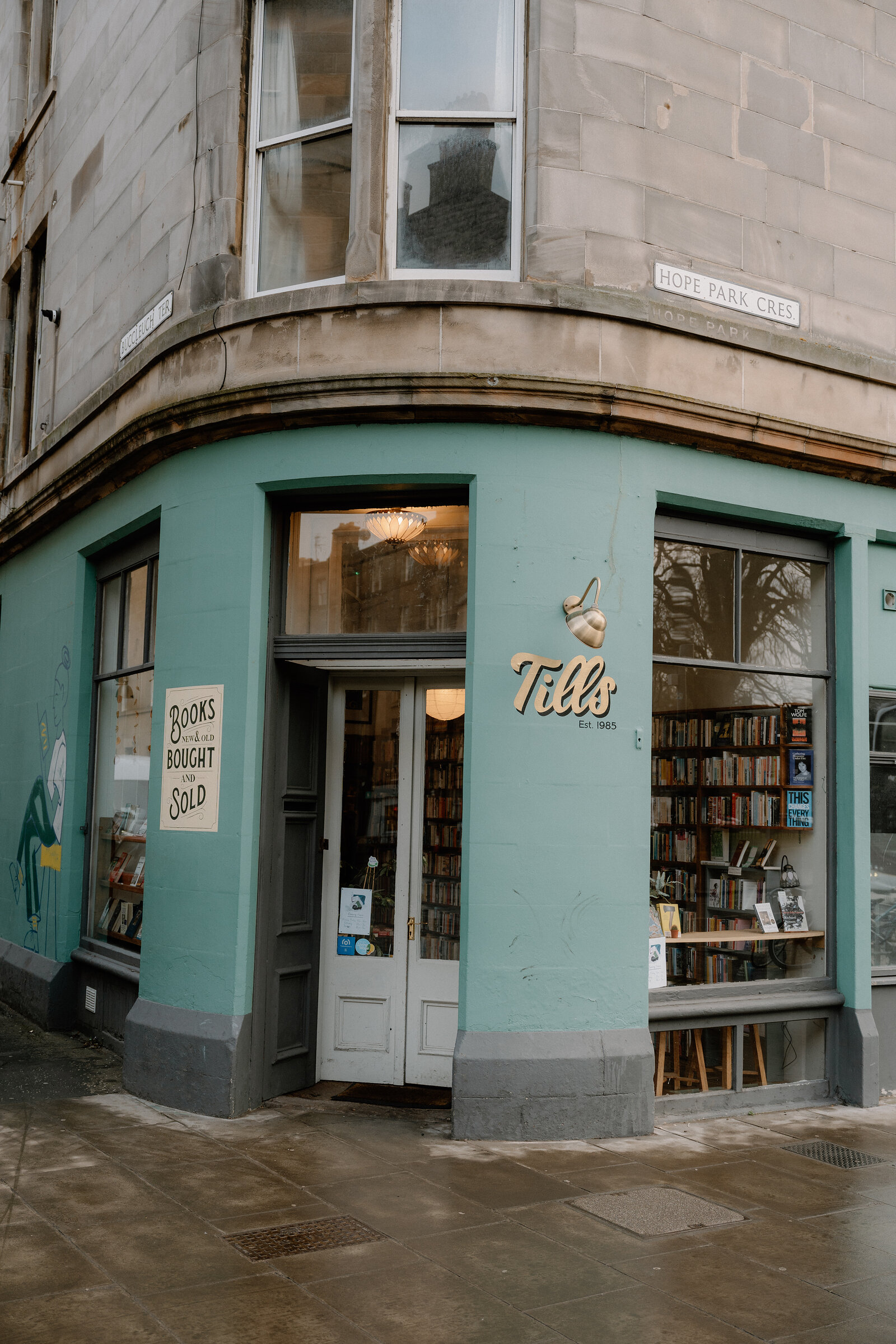 The turquoise corner shopfront of Till's bookshop, a sign reading Books Bought and Sold beside the door