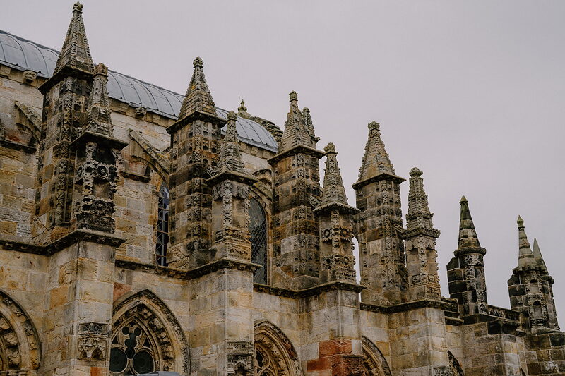 Rows of carved stone pinnacles crown Rosslyn Chapel's roofline.