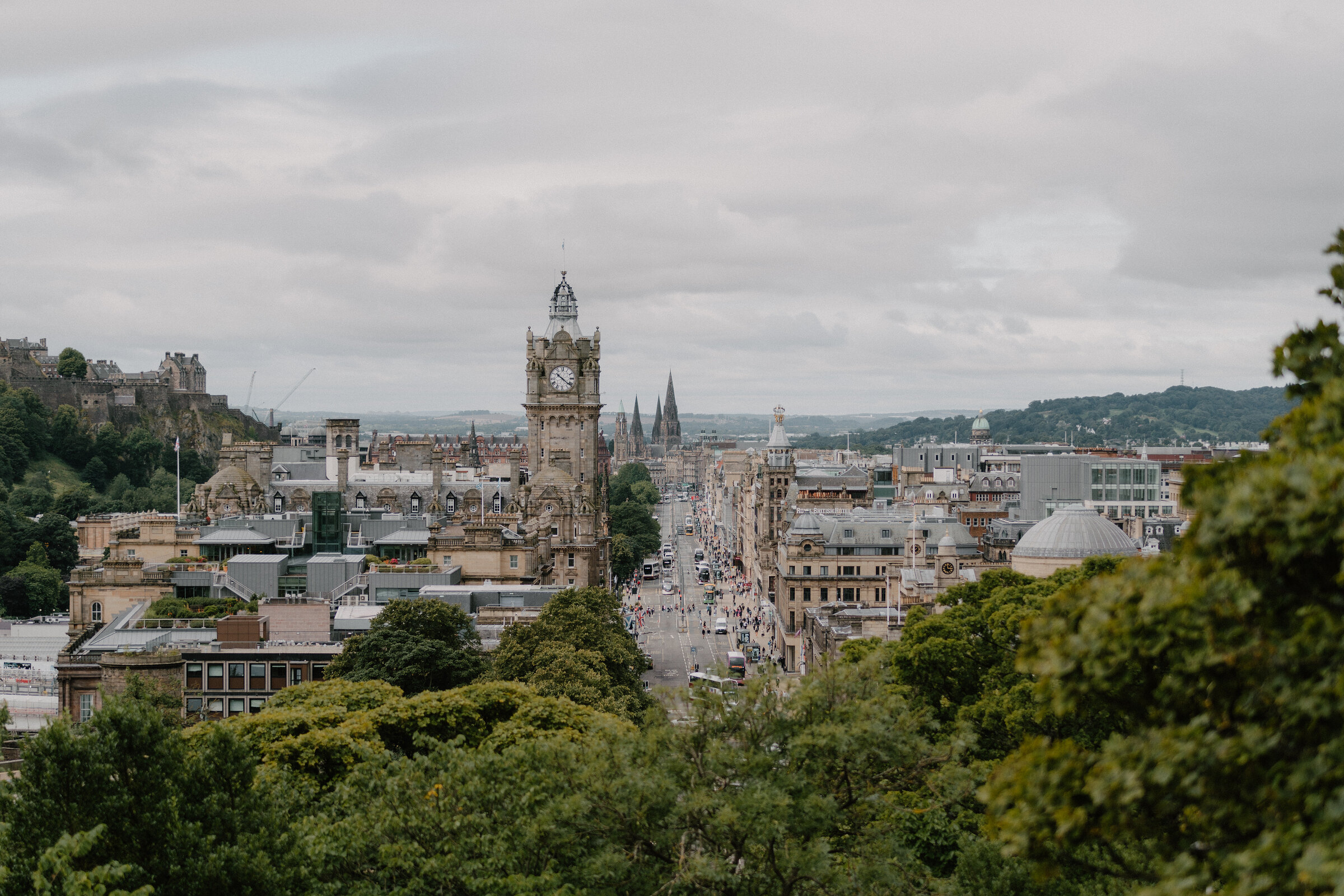 The Balmoral clock tower rising above Princes Street's buildings, Edinburgh Castle visible on the skyline.