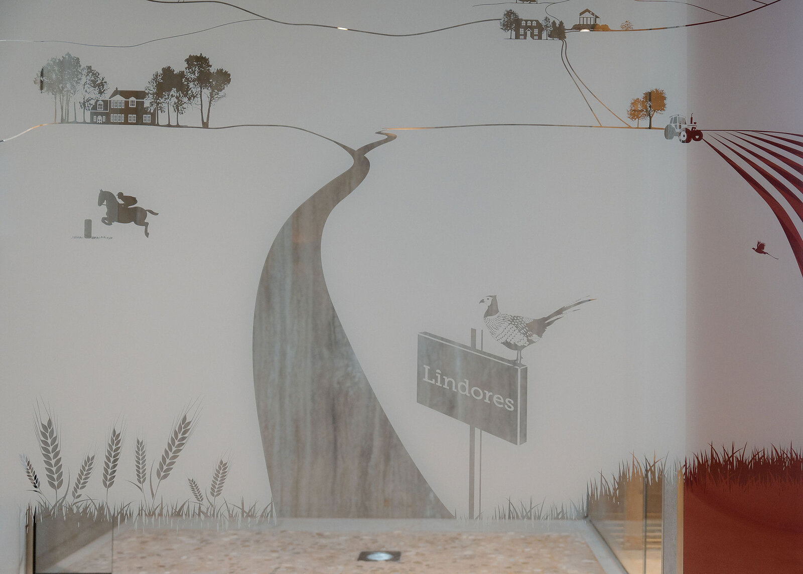 A frosted shower screen etched with a farm scene: a winding track, a horse and rider, a tractor and a pheasant on a Lindores sign.