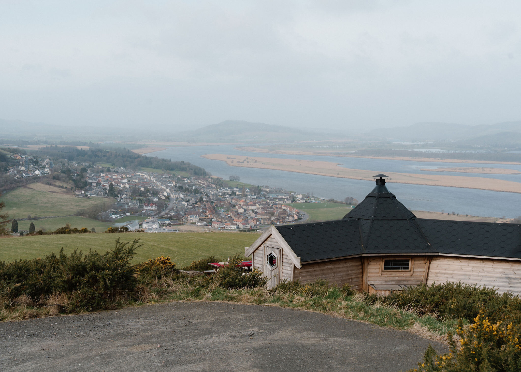 The Hide's black roof and chimney sit in the lower right corner, with Newburgh and the River Tay's reed islands below.