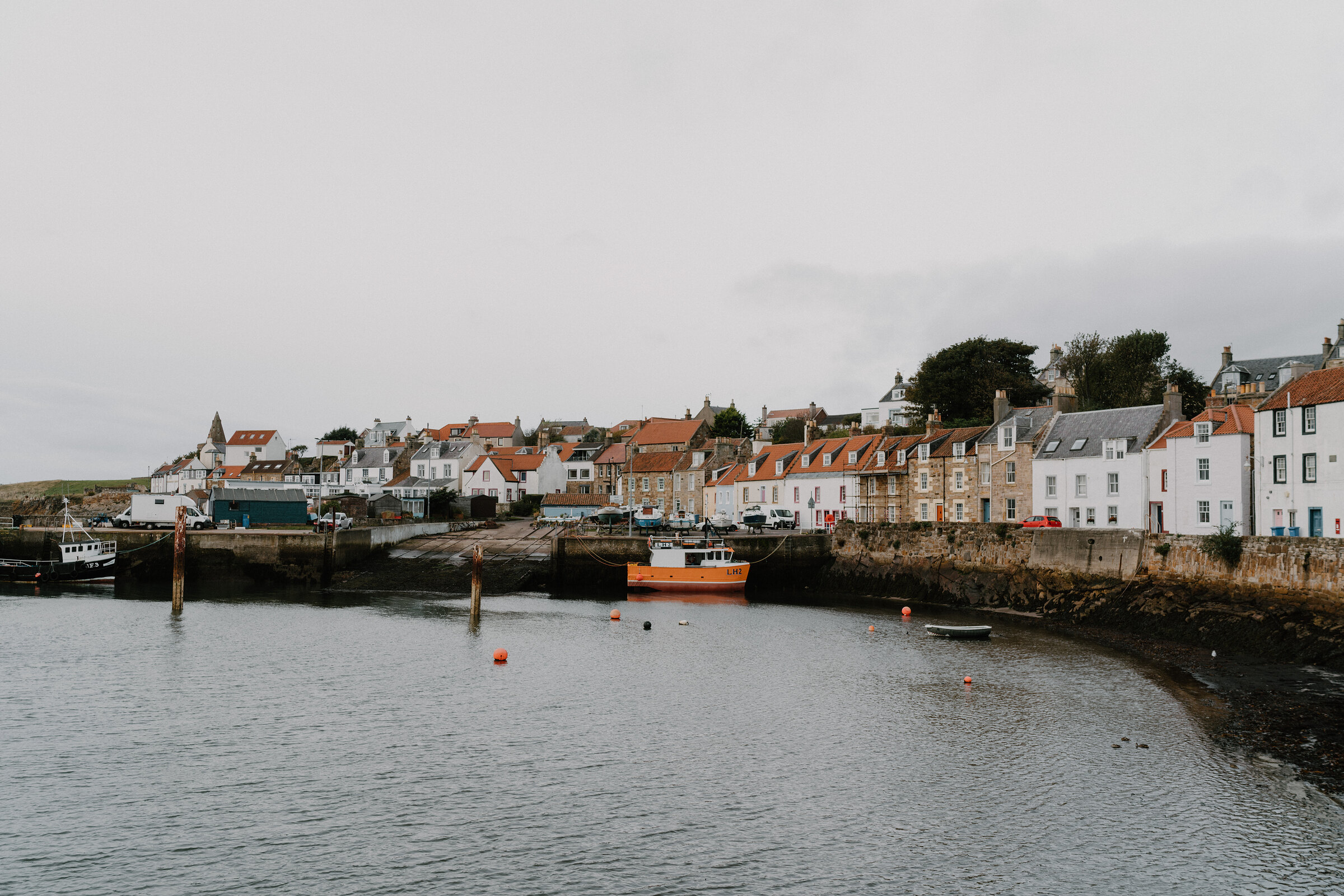 A small boat at low tide in St Monans harbour, in the East Neuk.