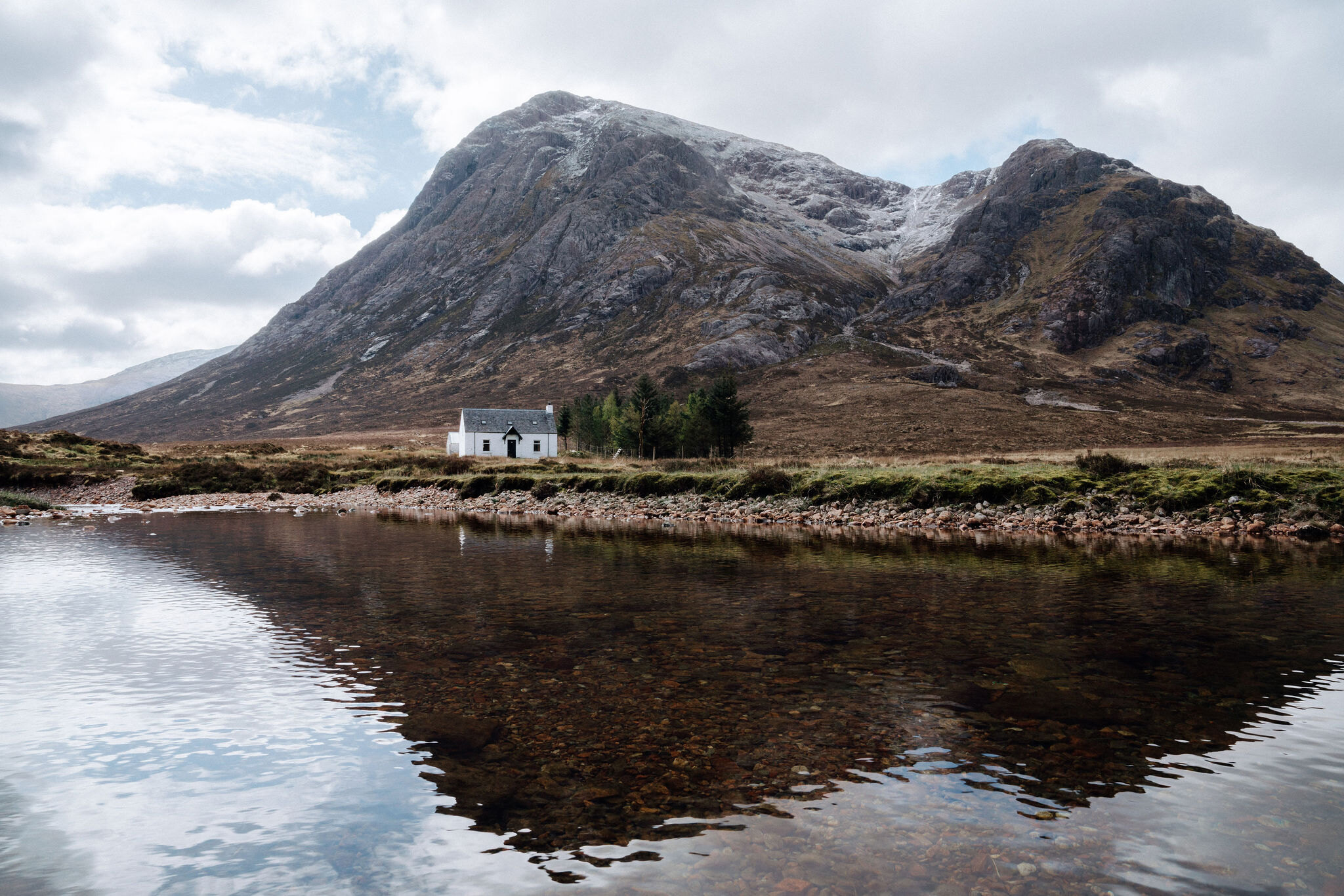 The Lagangarbh hut below the hill in autumn, a dusting of snow along the top.