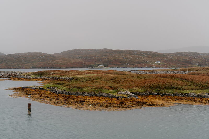 Machair grassland bordering the sea at Askernish Golf Club, hills rising across the water.