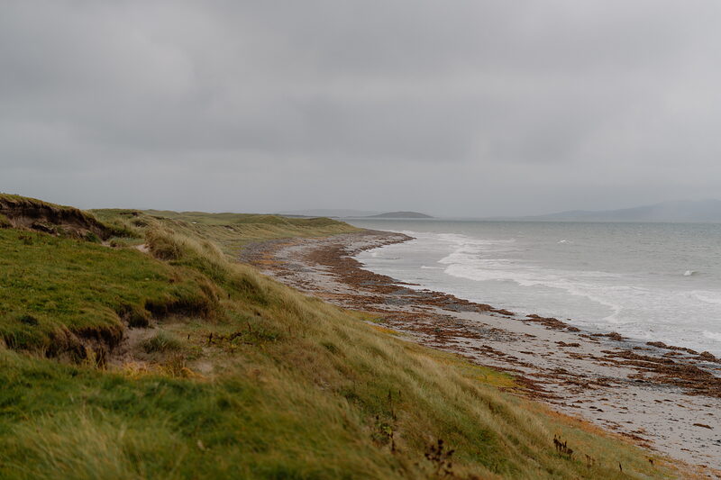 A sandy beach bordered by dunes and waves at Askernish Golf Club.