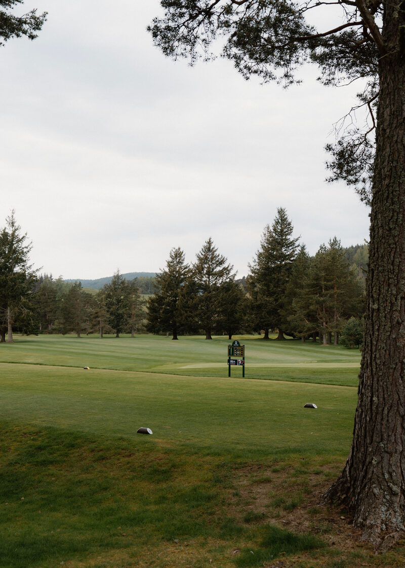 The 10th tee at Ballater Golf Club, with The Coyles sign and the fairway running to tall conifers.