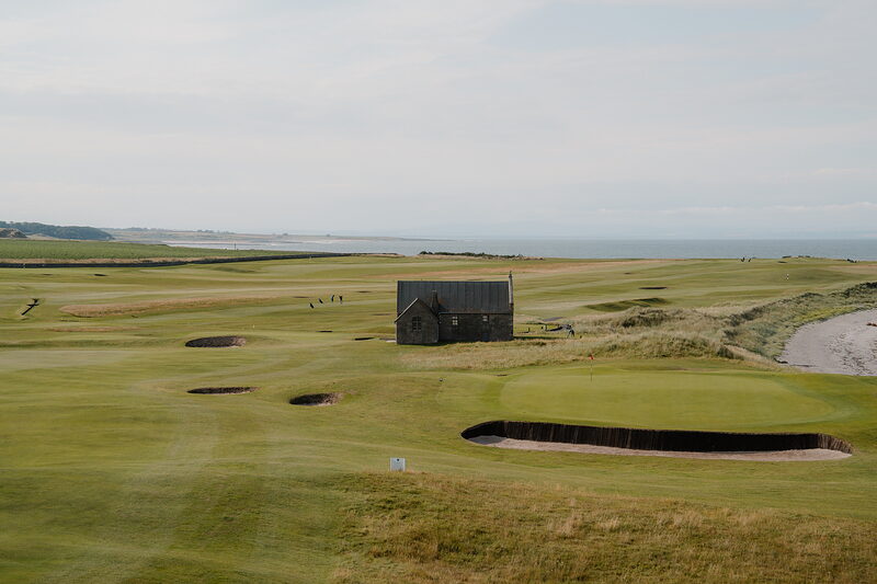 A stone shelter surrounded by bunkers on the fairway at Crail, sea and coastline beyond