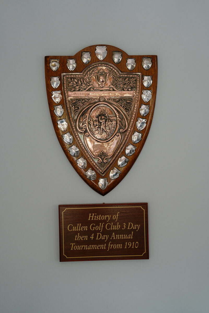 A silver shield trophy plaque above a sign reading History of Cullen Golf Club 3 Day then 4 Day Annual Tournament from 1910