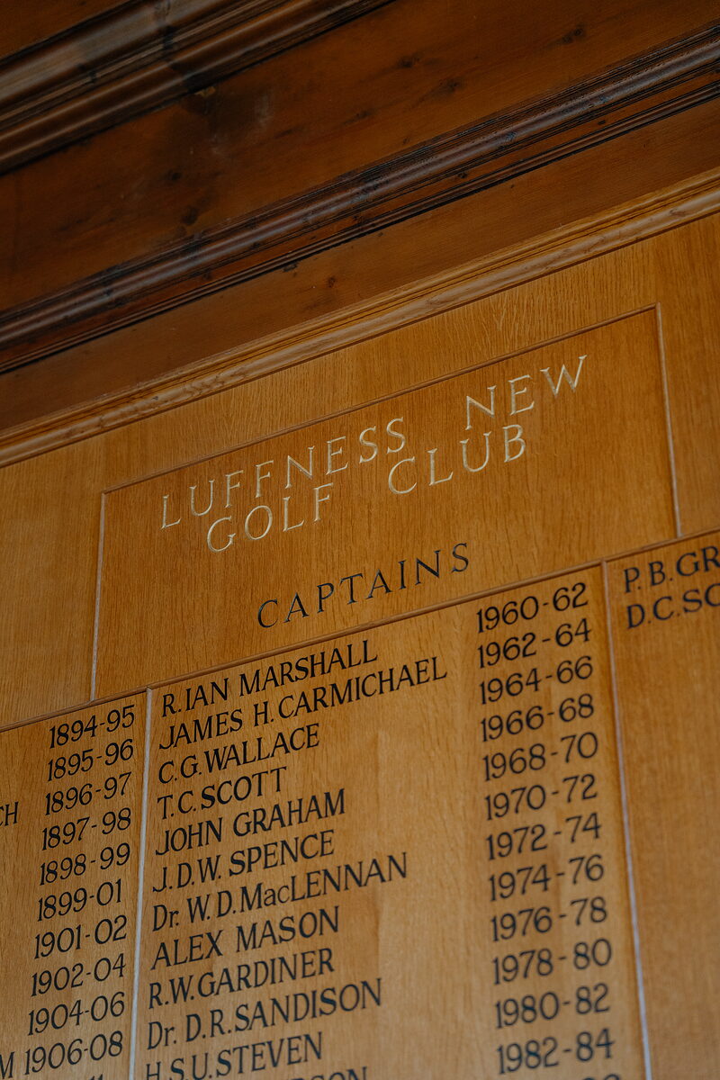 An honours board listing Luffness New Golf Club captains by year, carved into wood panelling