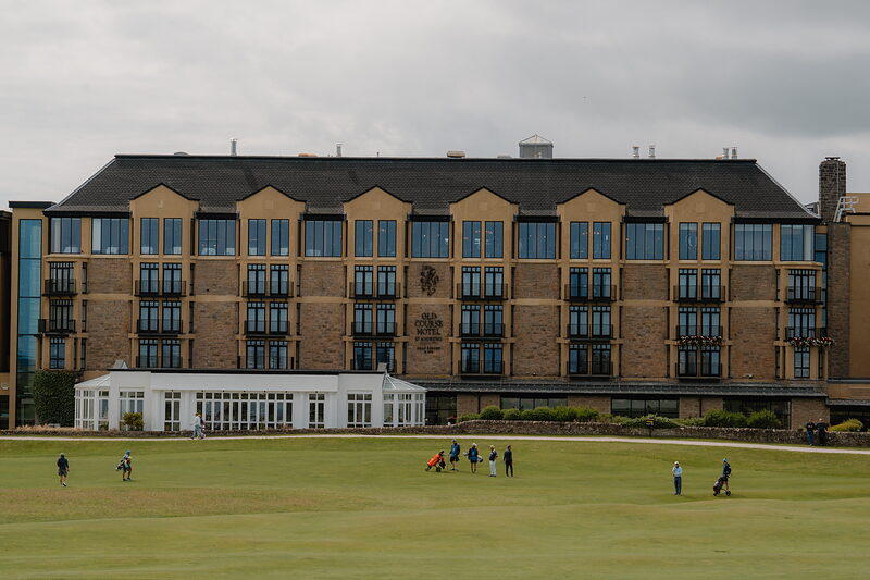 Golfers on the fairway at St Andrews Links, the Hamilton Grand building rising behind them.