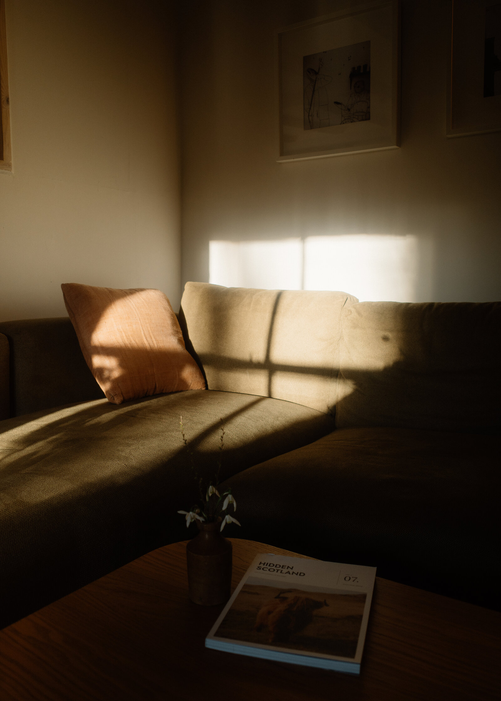 The sofa in a bar of sunlight, a copy of Hidden Scotland on the table in front.