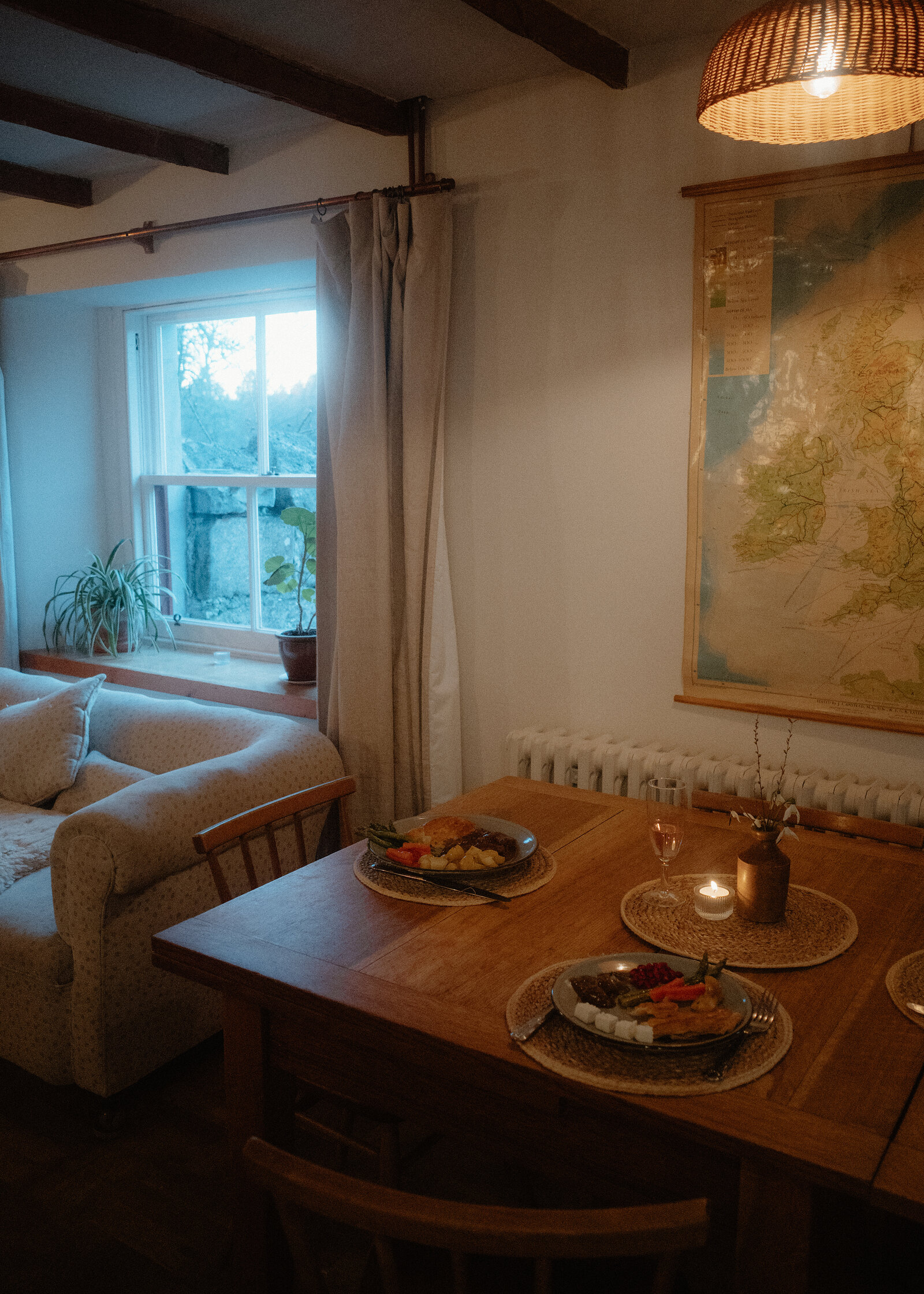 West Dell's dining table laid for supper by the window, the old map on the wall behind.