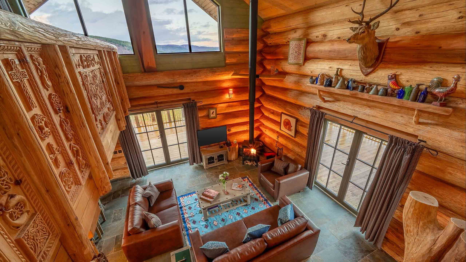 From the carved mezzanine rail down into Aquila's living room, the stove lit between the tall windows.