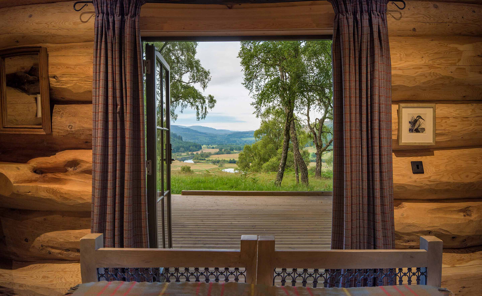 From Certhia's bed through open glass doors, the deck and birches frame the glen far below.