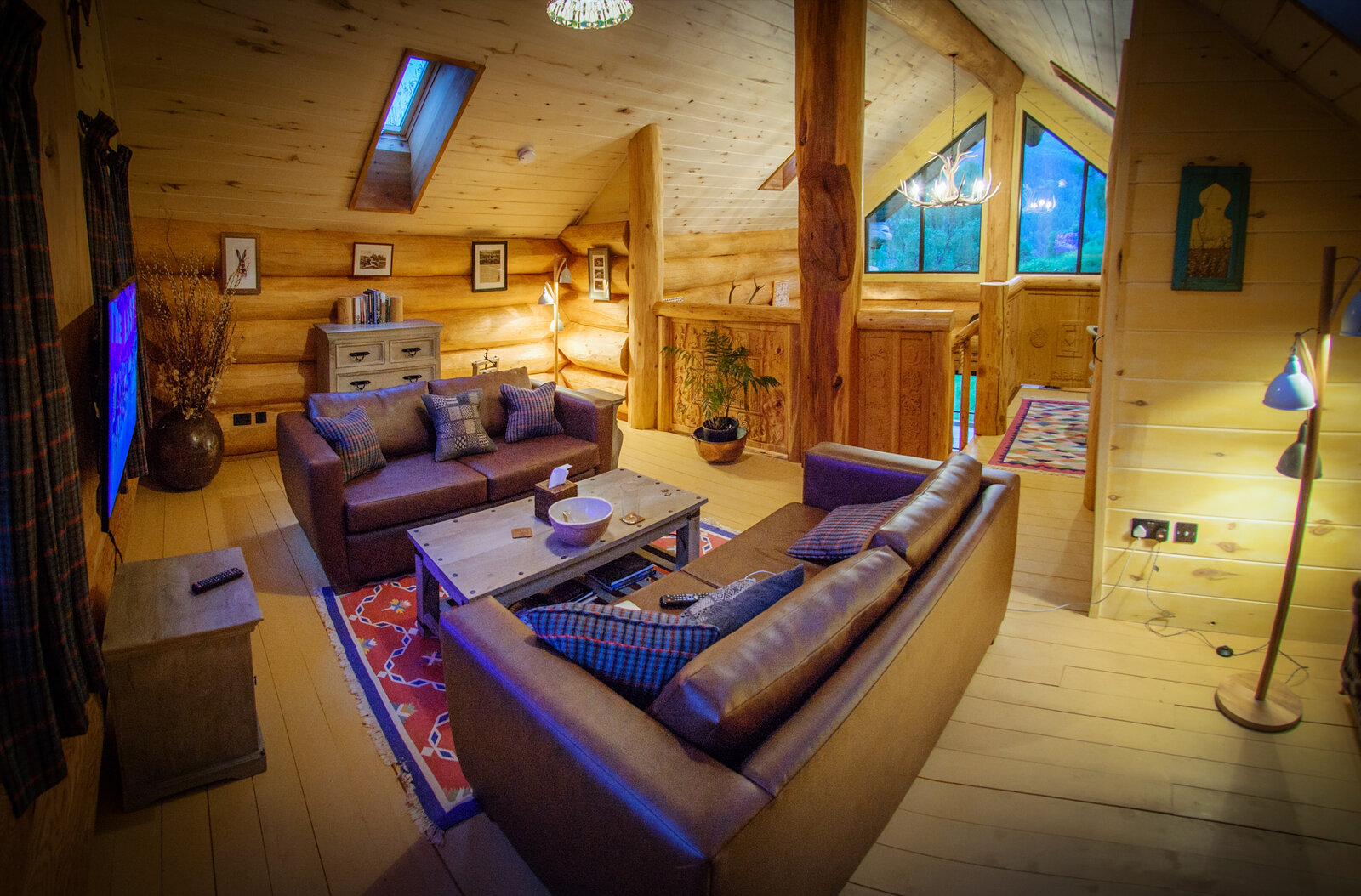 Strix's upstairs sitting room under the gable windows: leather sofas round a table, a skylight overhead.