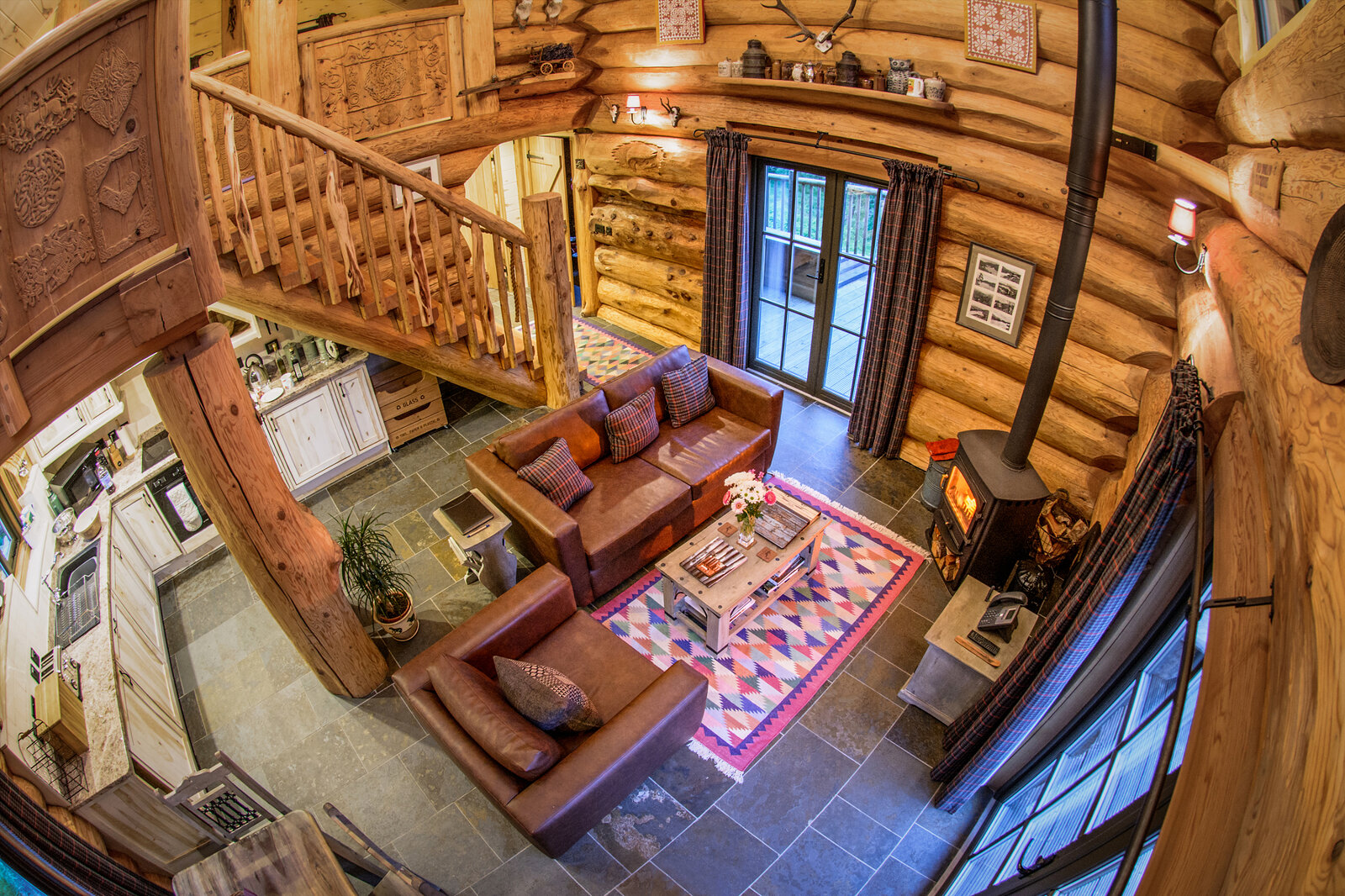 Looking down on Strix's kitchen, sofas and stove from the top of the log stair.