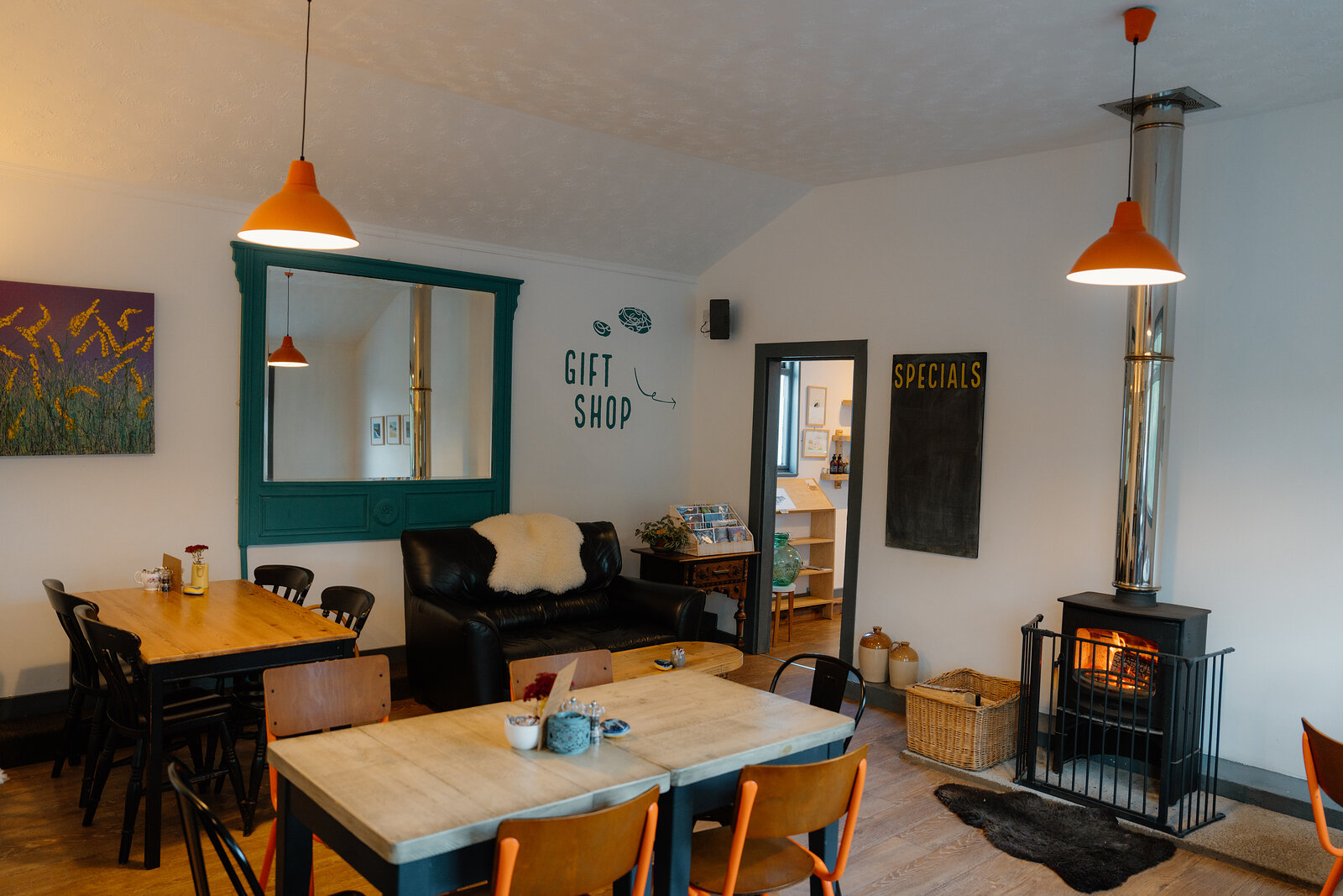The wood-burning stove and a leather sofa inside Cafe Lephin, a specials board on the wall.