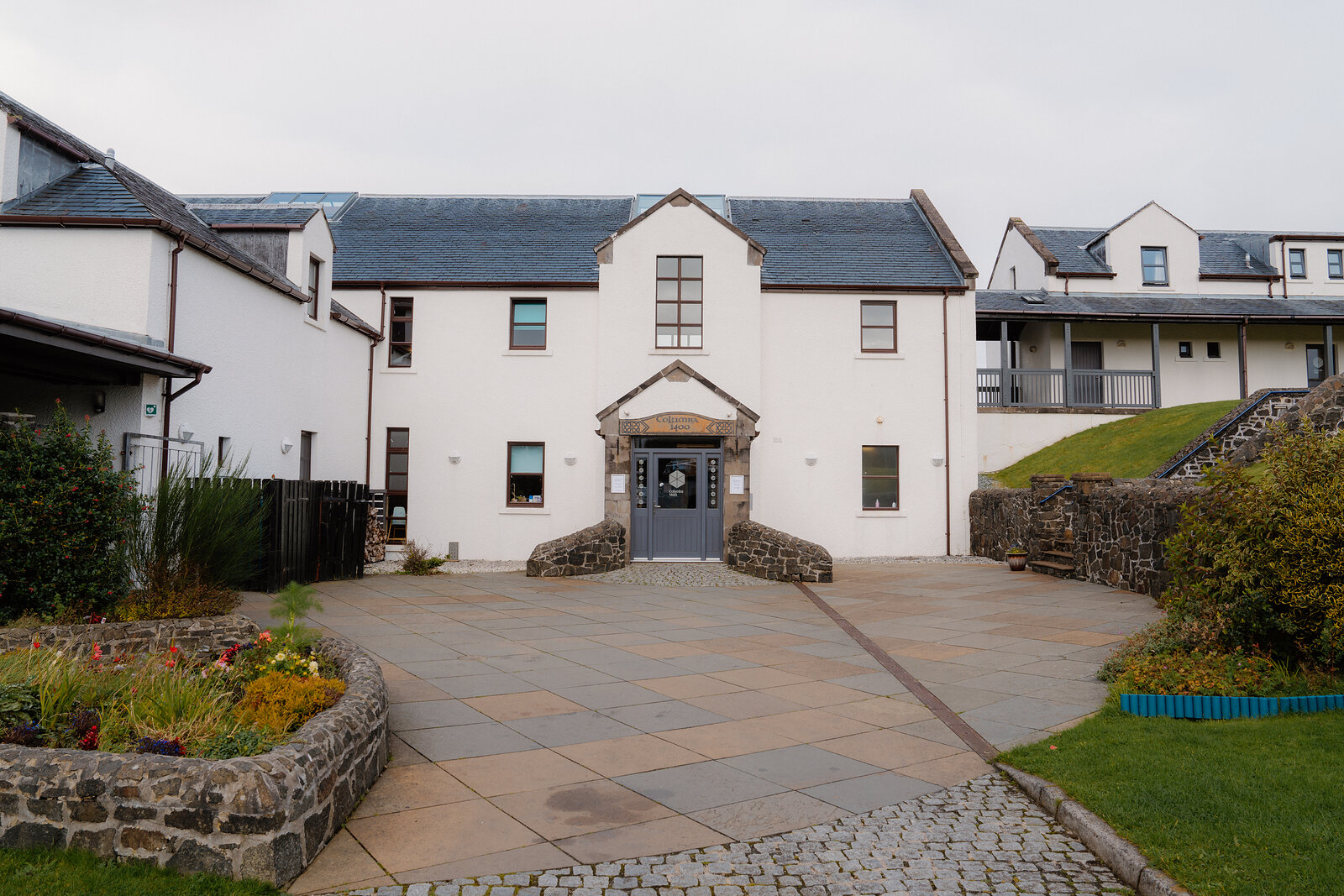 White buildings enclose a stone-paved courtyard.